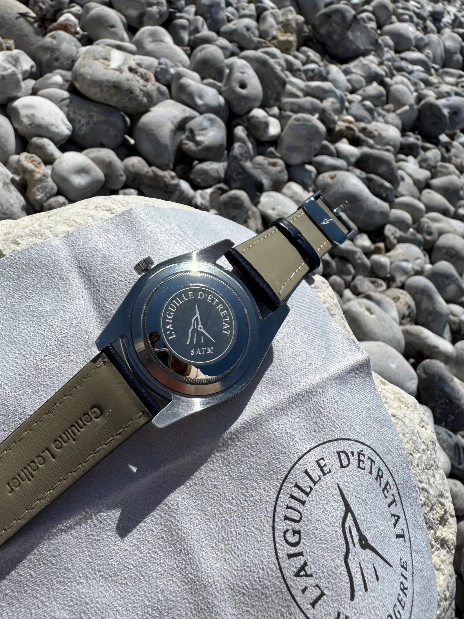Fond de boîte gravé L'Aiguille d'Étretat, posé sur les galets de la plage